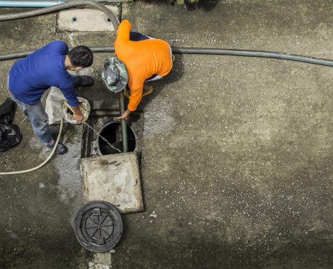 Pipe cleaning drainpipe by two workers to get rid of obstruction Passage of water in the rainy season in image bird eye view.