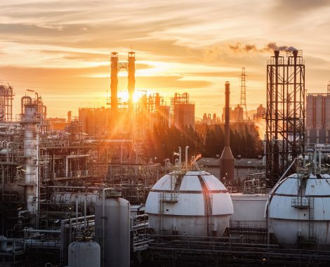 Gas storage sphere tanks in petrochemical industry or oil and gas refinery plant at evening, Manufacturing of petroleum industrial plant with gas column and smoke stacks on sunset sky background